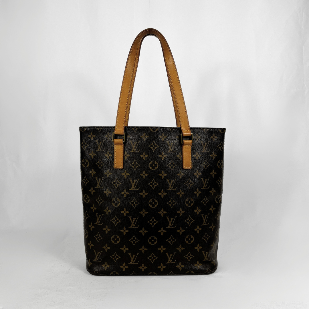 A Louis Vuitton monogram canvas tote bag with tan leather shoulder straps, photographed against a light gray studio background.