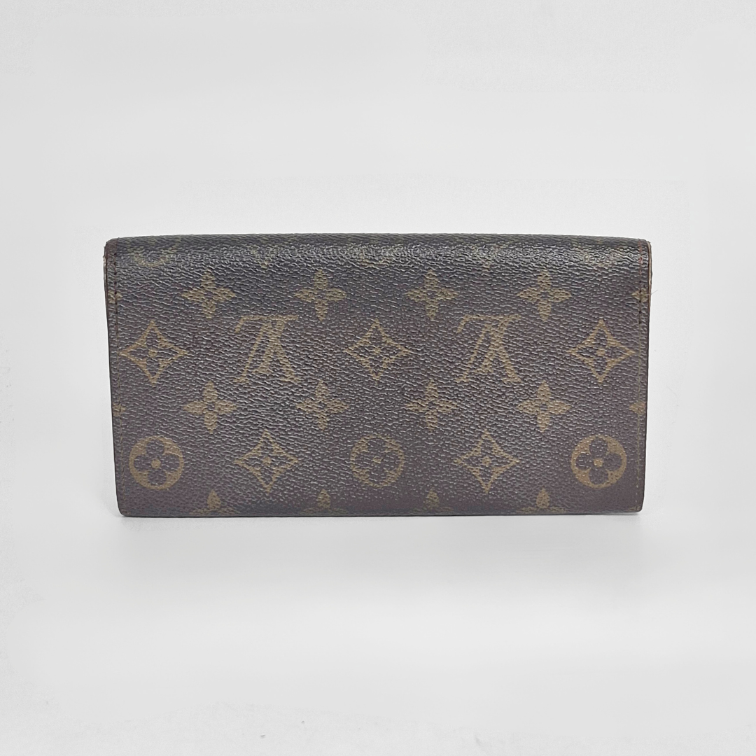 Louis Vuitton wallet with monogram pattern on a white background