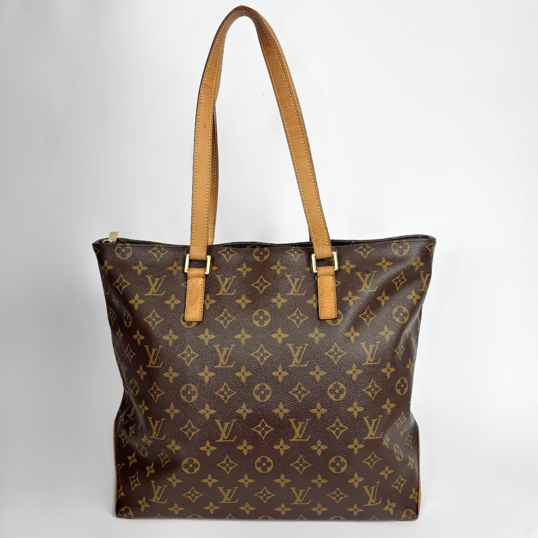 Louis Vuitton monogram canvas tote bag with tan leather shoulder straps and gold-tone hardware, photographed against a light gray studio background.