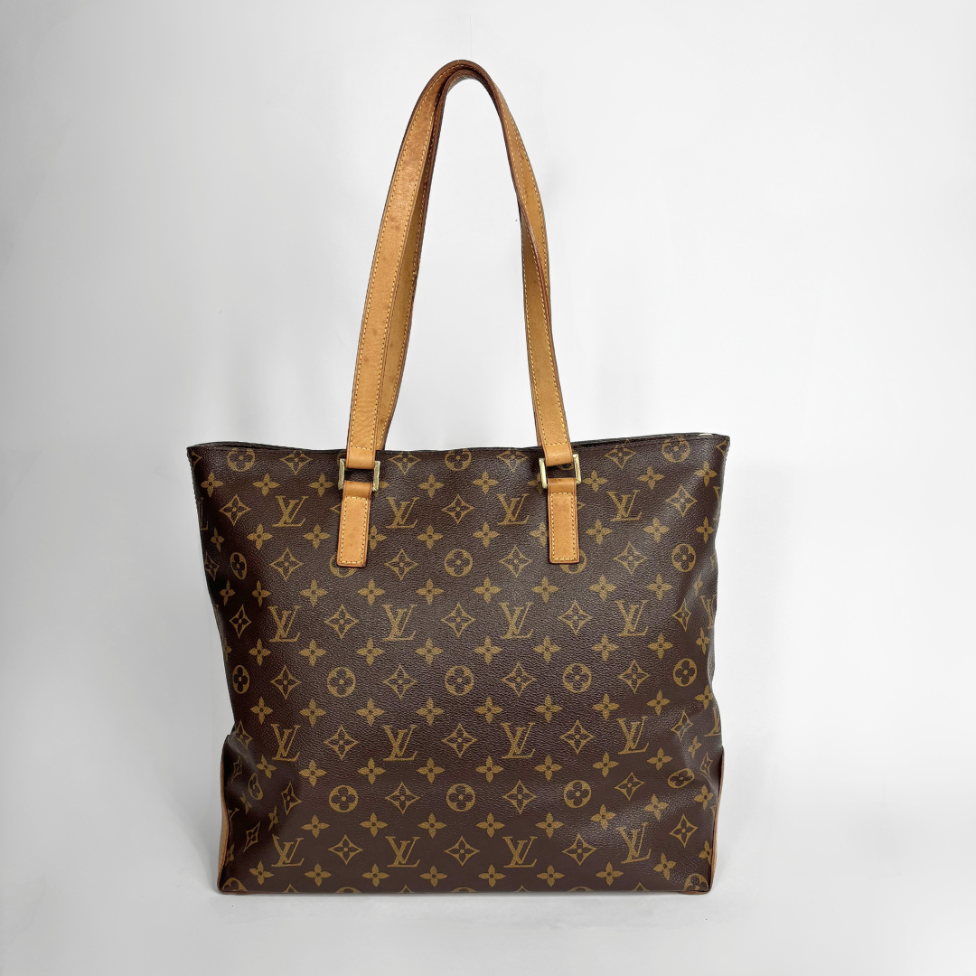 A Louis Vuitton monogram canvas tote bag with tan leather shoulder straps and gold-tone hardware, photographed against a neutral light gray background.