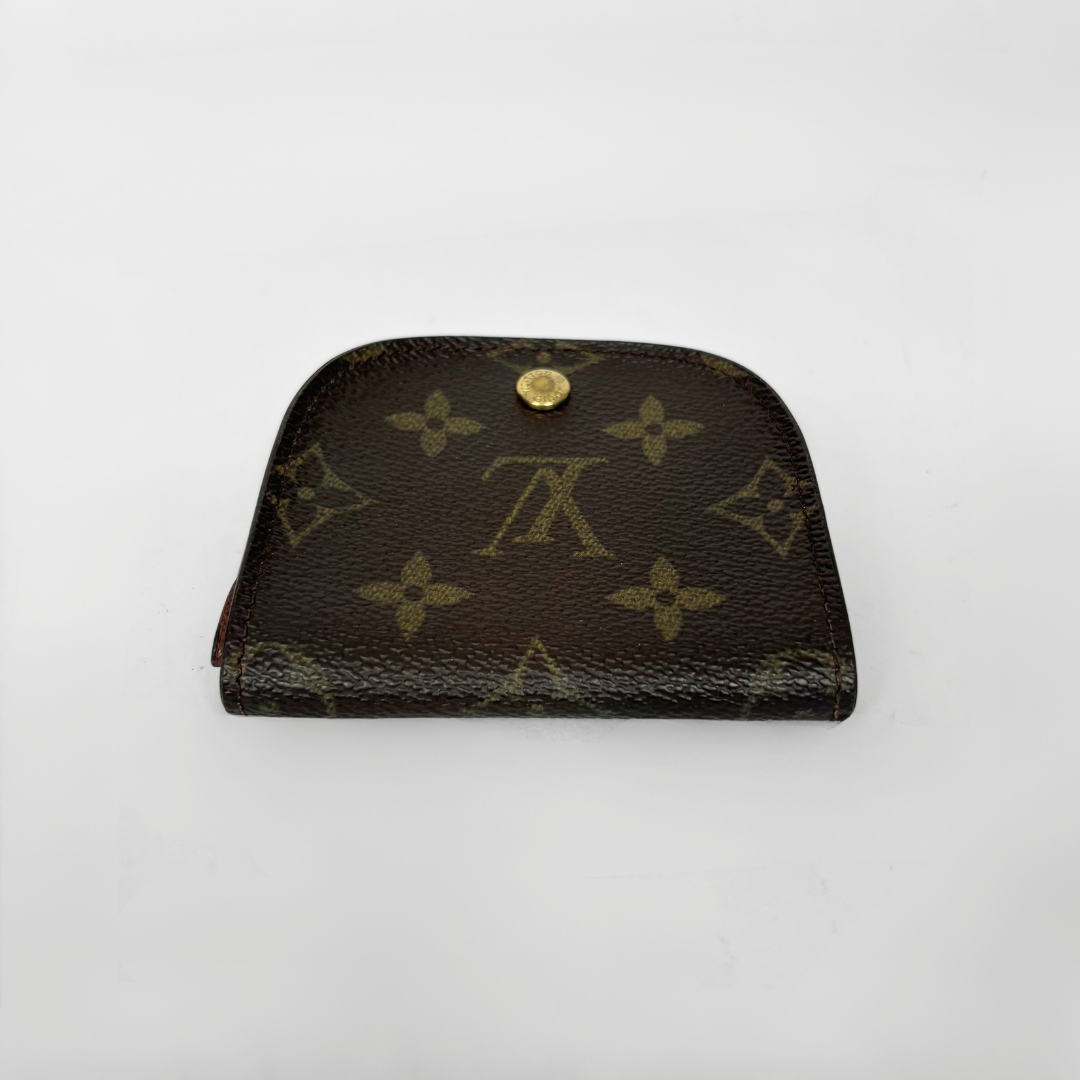 Louis Vuitton wallet with monogram pattern on a white background
