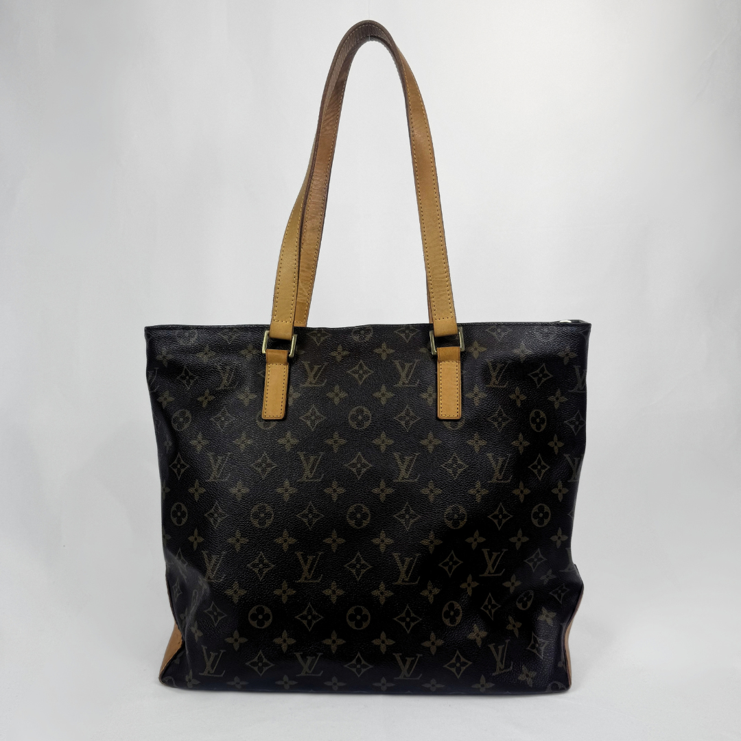 Louis Vuitton monogram canvas tote bag with tan leather shoulder straps and gold-tone hardware, photographed against a light gray studio background.