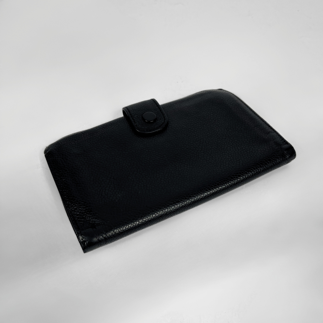 A black textured leather wallet with a snap-button closure, photographed on a plain light gray background.