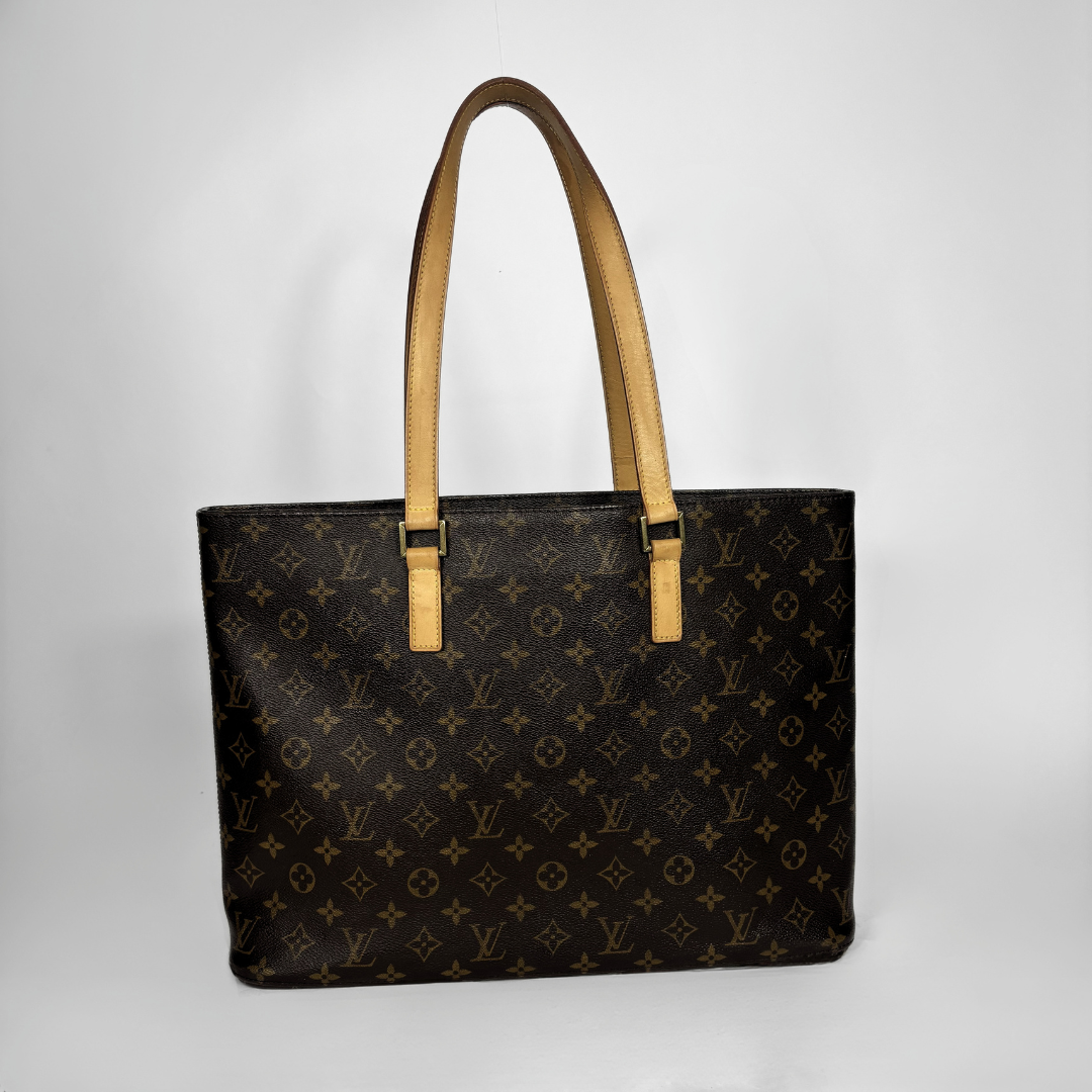 Louis Vuitton monogram canvas tote bag with tan leather shoulder straps, shown against a neutral light gray background.