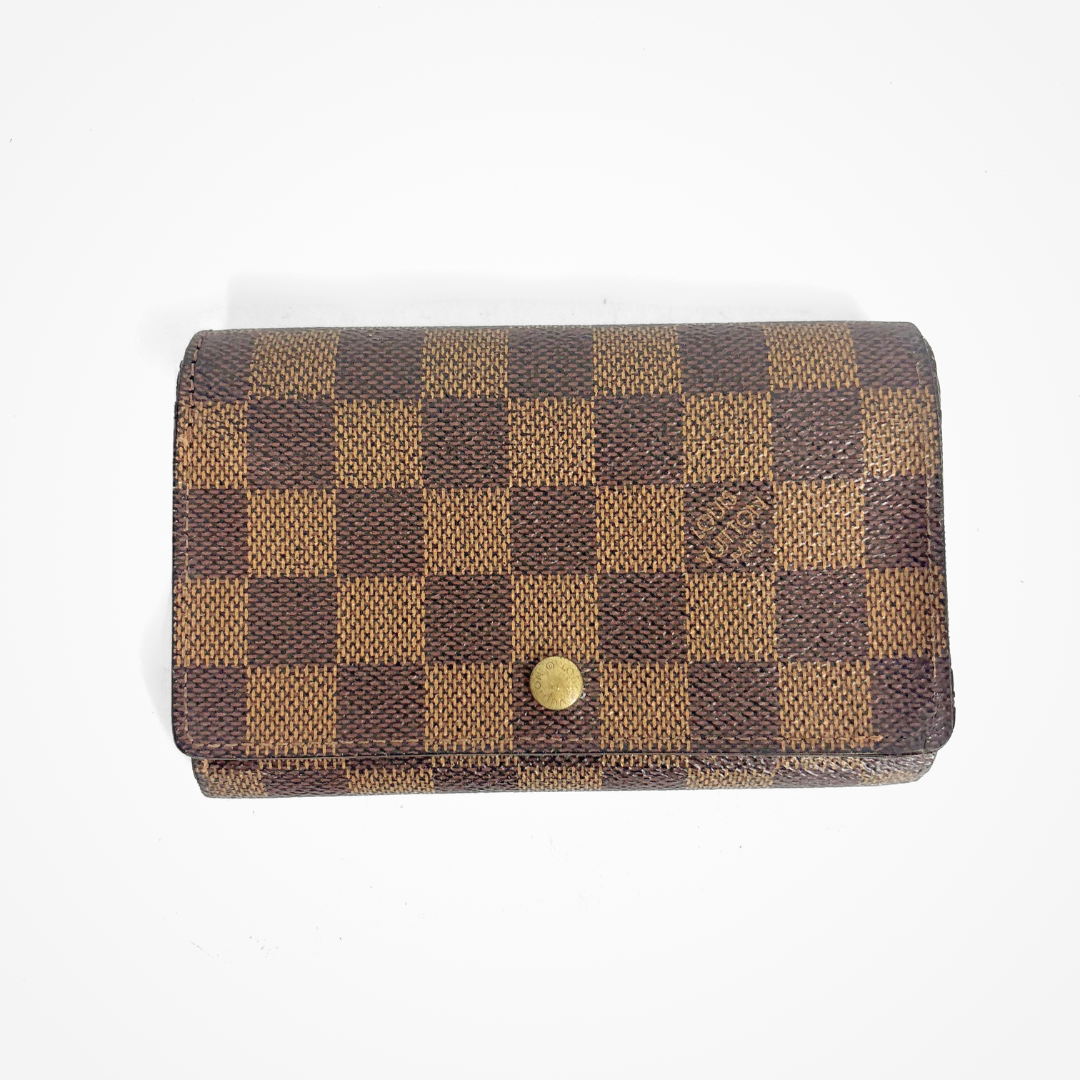 Brown checkered LV wallet with gold accents on a white background