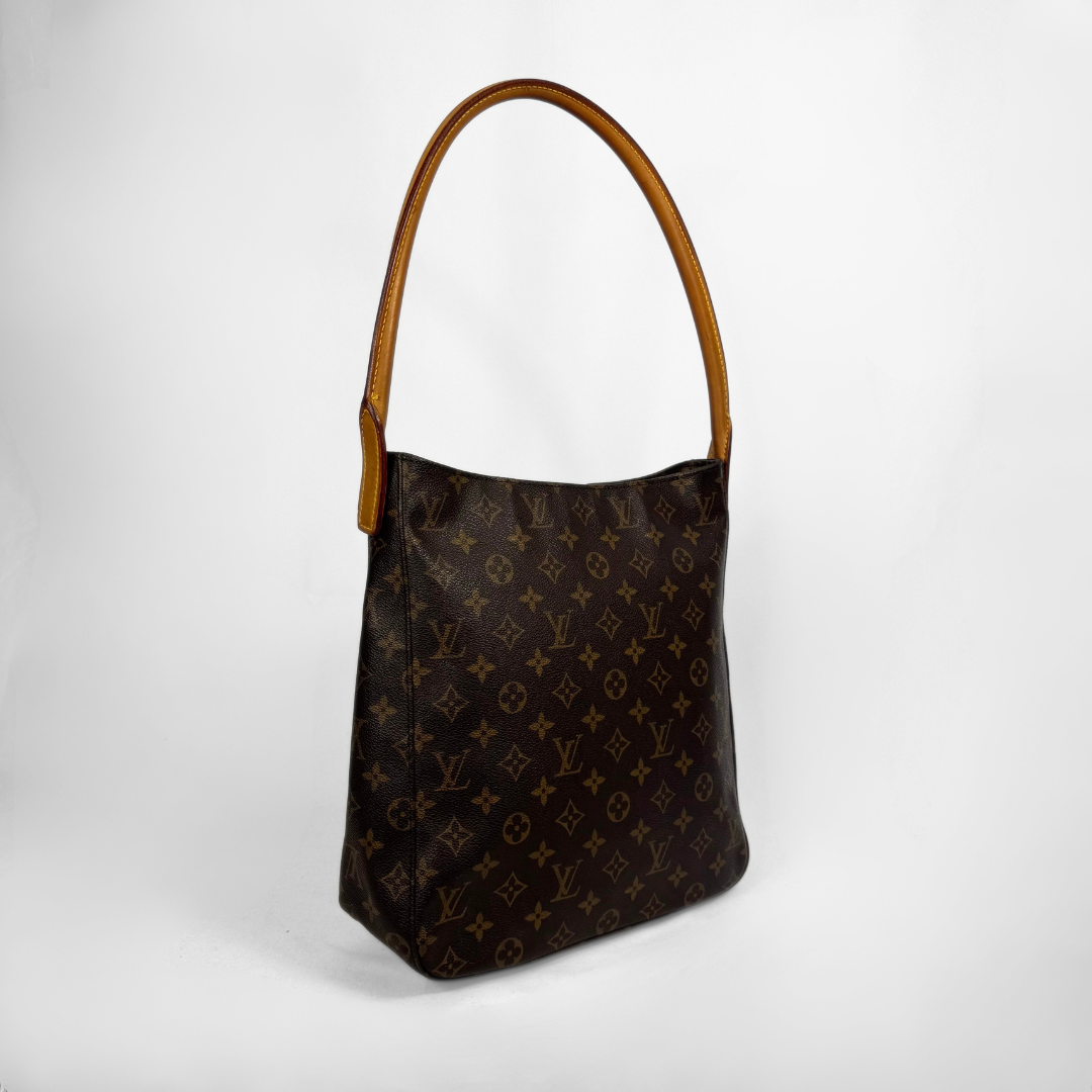A Louis Vuitton shoulder bag in brown monogram canvas with a tan leather shoulder strap, photographed against a light gray studio background.