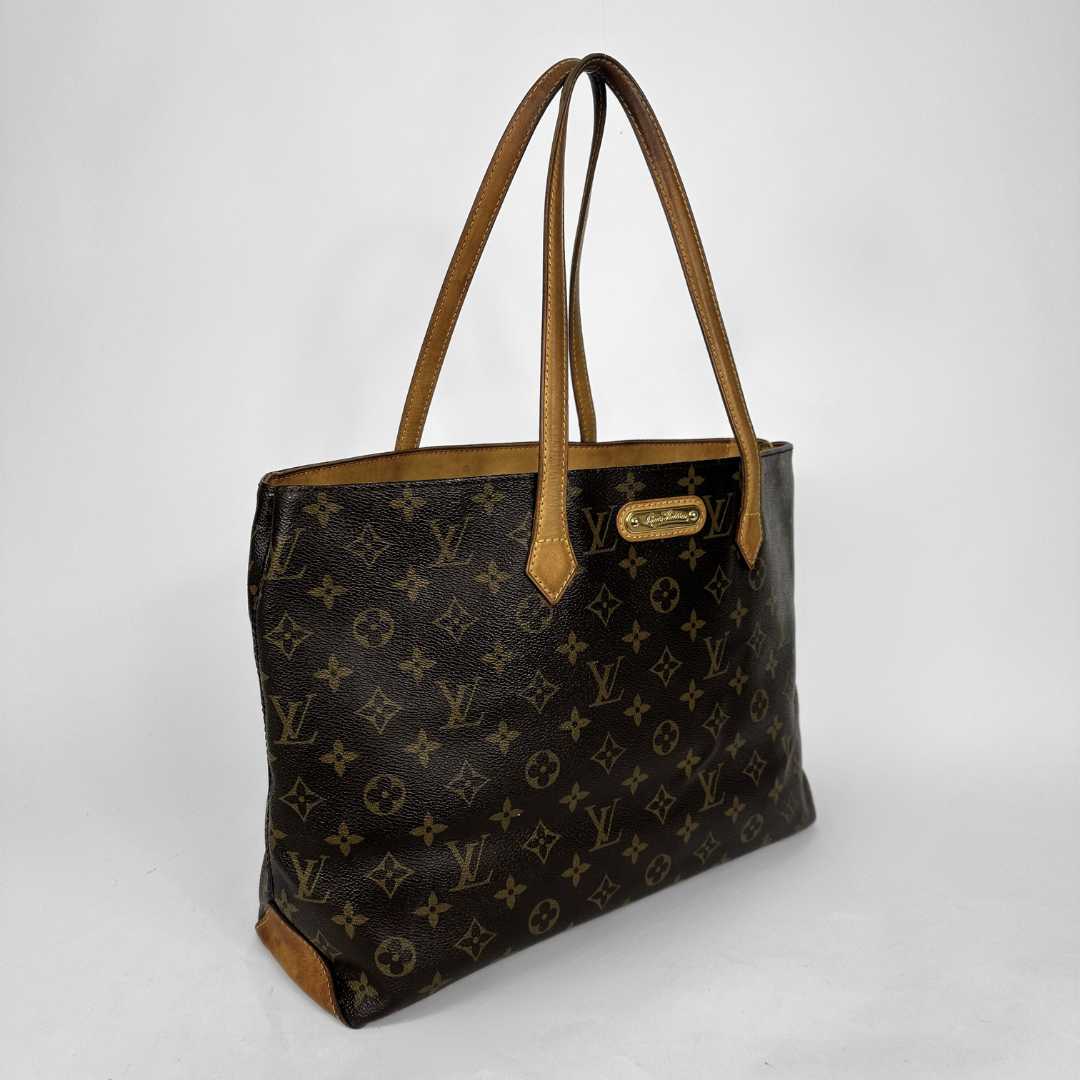 Louis Vuitton monogram canvas tote bag with brown leather handles and trim, shown on a light gray background.