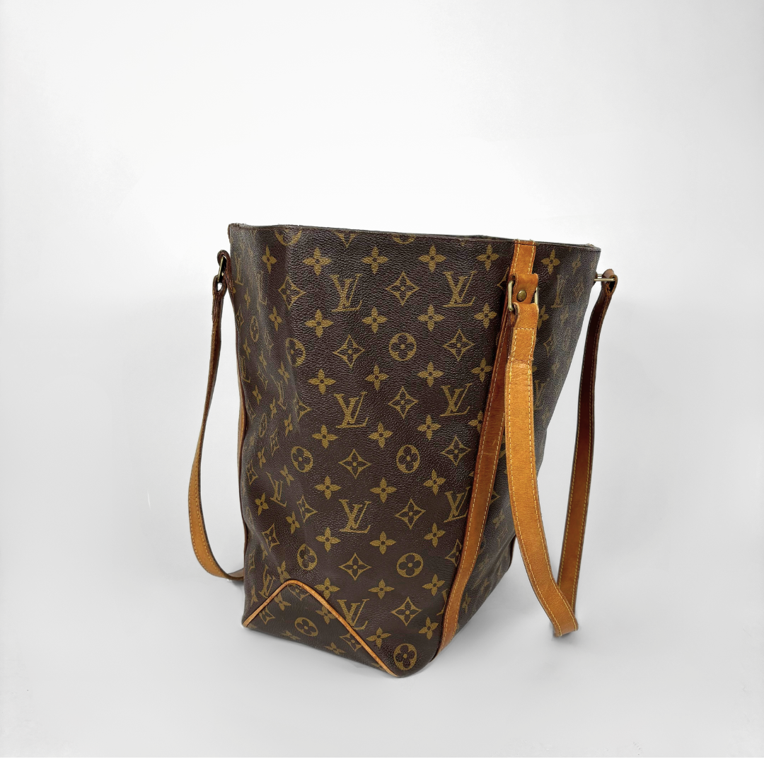 Brown monogram handbag with tan leather accents on a white background