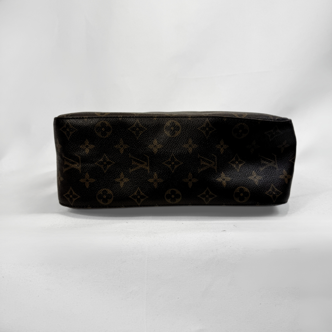 A Louis Vuitton monogram canvas pouch in dark brown with tan monogram motifs, photographed against a white studio background.