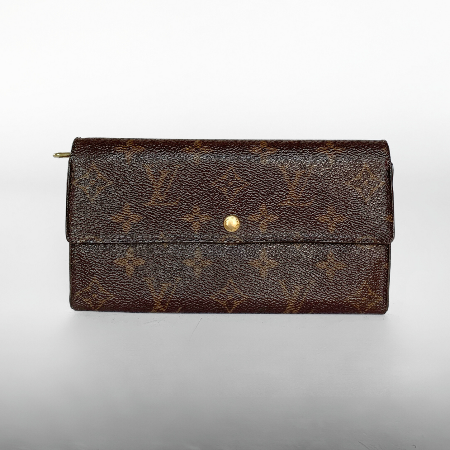 A Louis Vuitton monogram canvas long wallet in dark brown with a gold snap button closure, photographed against a neutral light gray background.