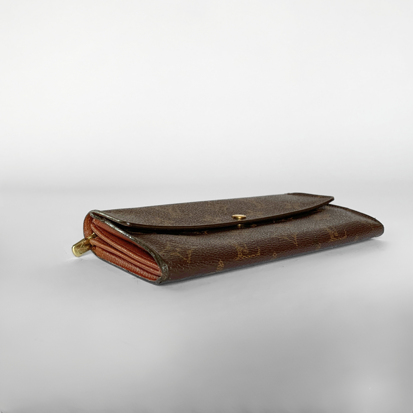 A vintage Louis Vuitton monogram wallet in brown coated canvas with gold-tone hardware, shown on a light gray gradient background.
