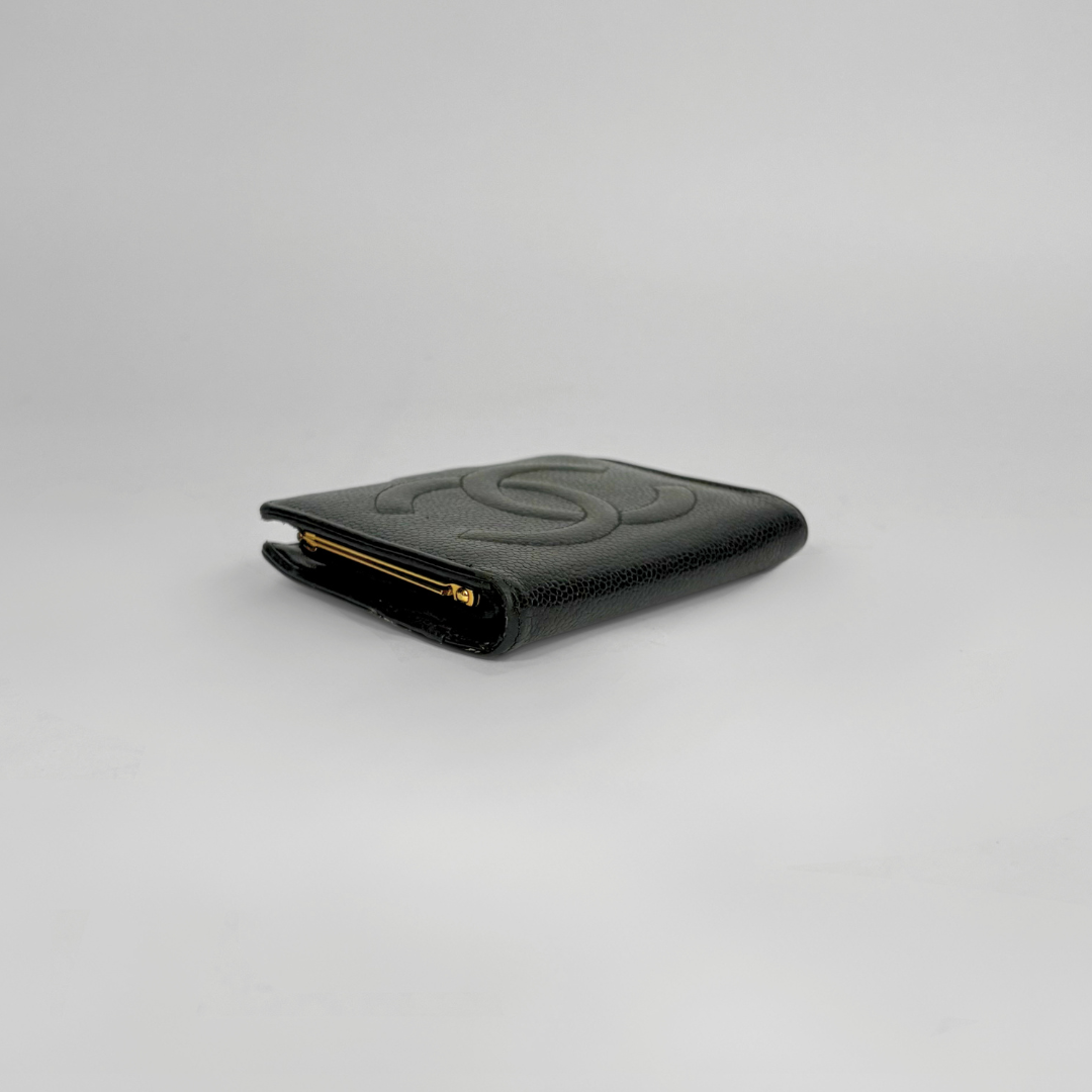Black wallet with gold zipper on a light gray background