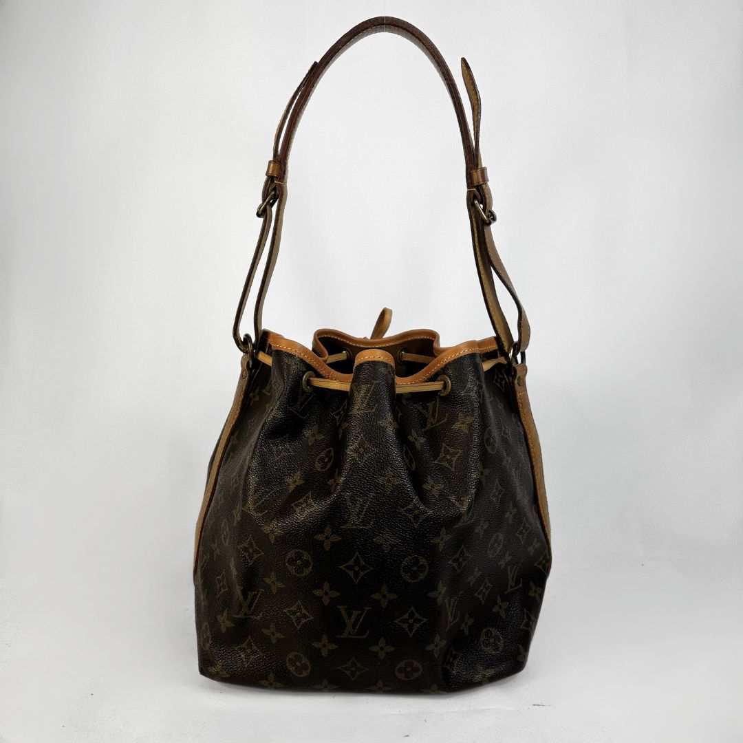 Louis Vuitton monogram canvas bucket bag with brown leather trim and shoulder strap, shown against a plain light gray background.