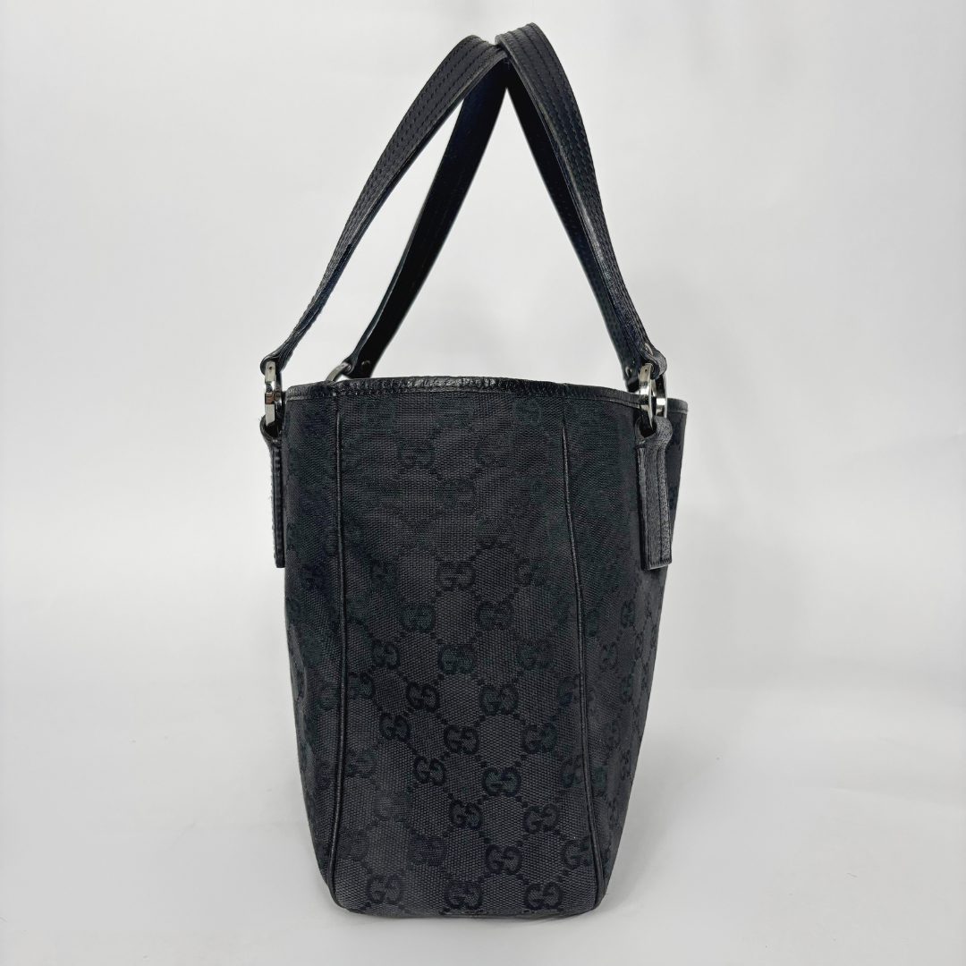 Black textured handbag with brand logo on a light gray background