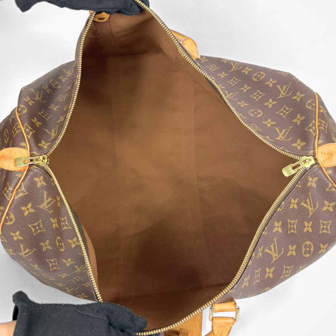 Brown leather bag with gold monogram pattern on a white background