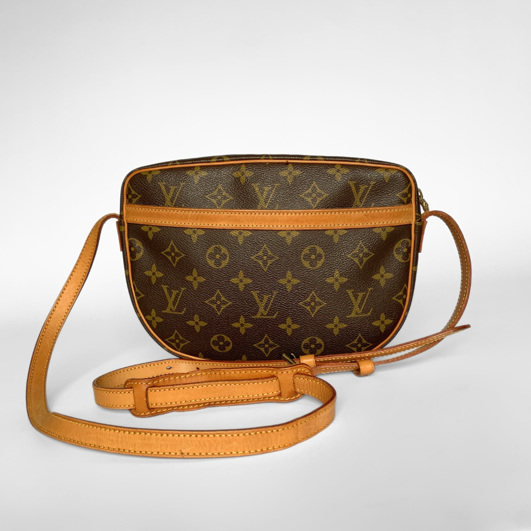 Brown monogram handbag with tan leather strap on a white background
