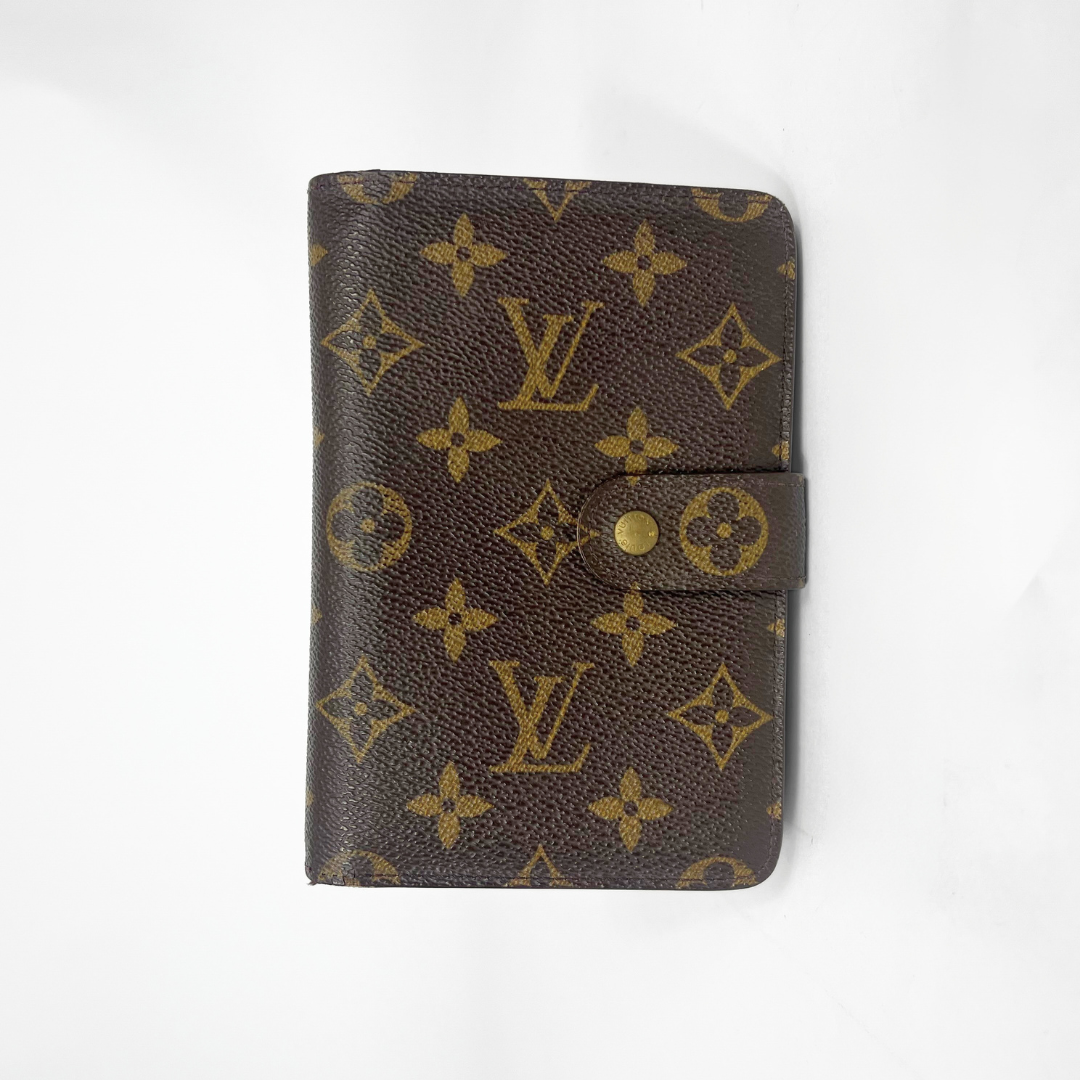 Brown wallet with gold monogram pattern on a white background