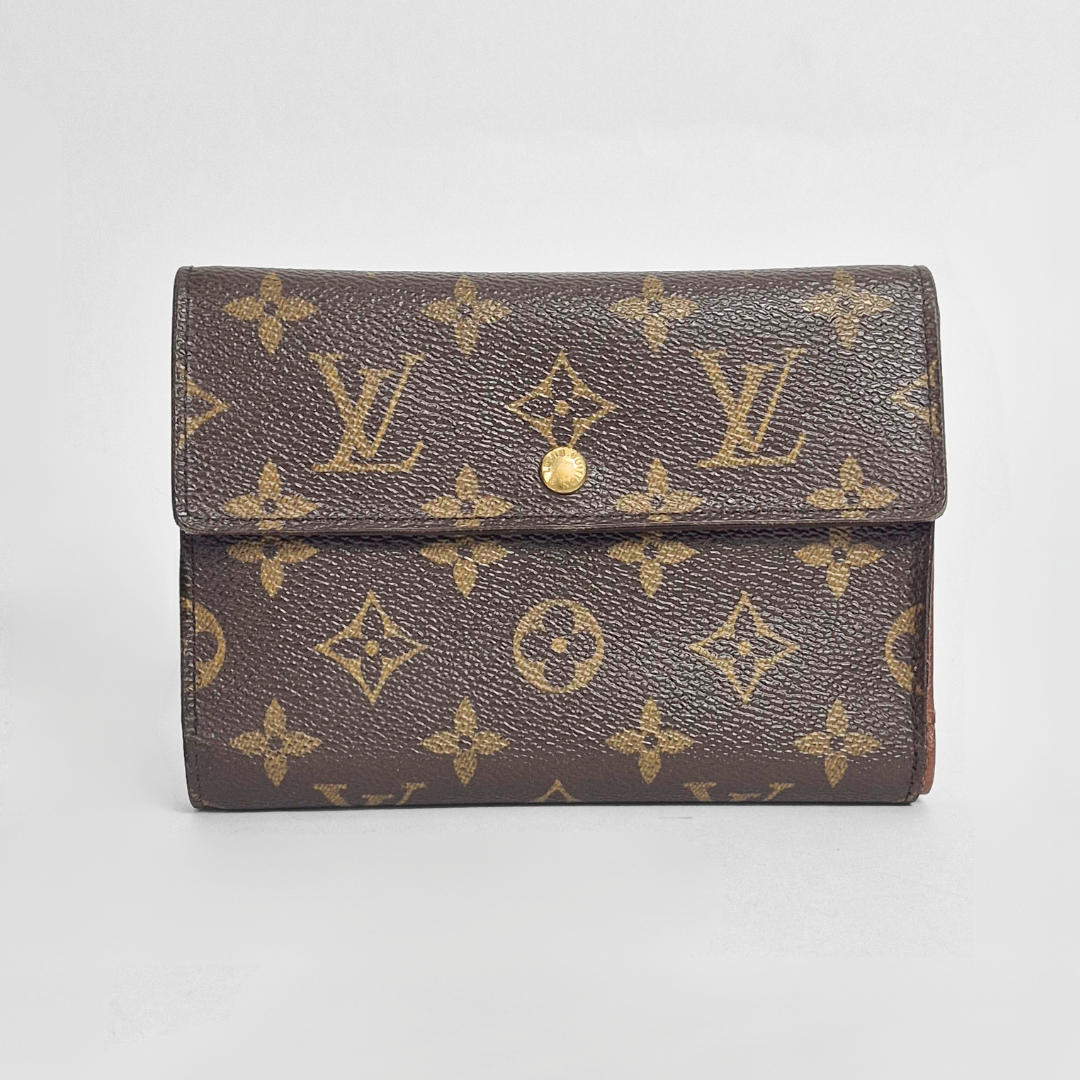 Louis Vuitton wallet with monogram pattern on a light gray background
