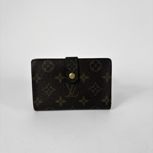 A Louis Vuitton monogram canvas wallet in black with a gold-tone snap button closure, photographed on a neutral light gray background.