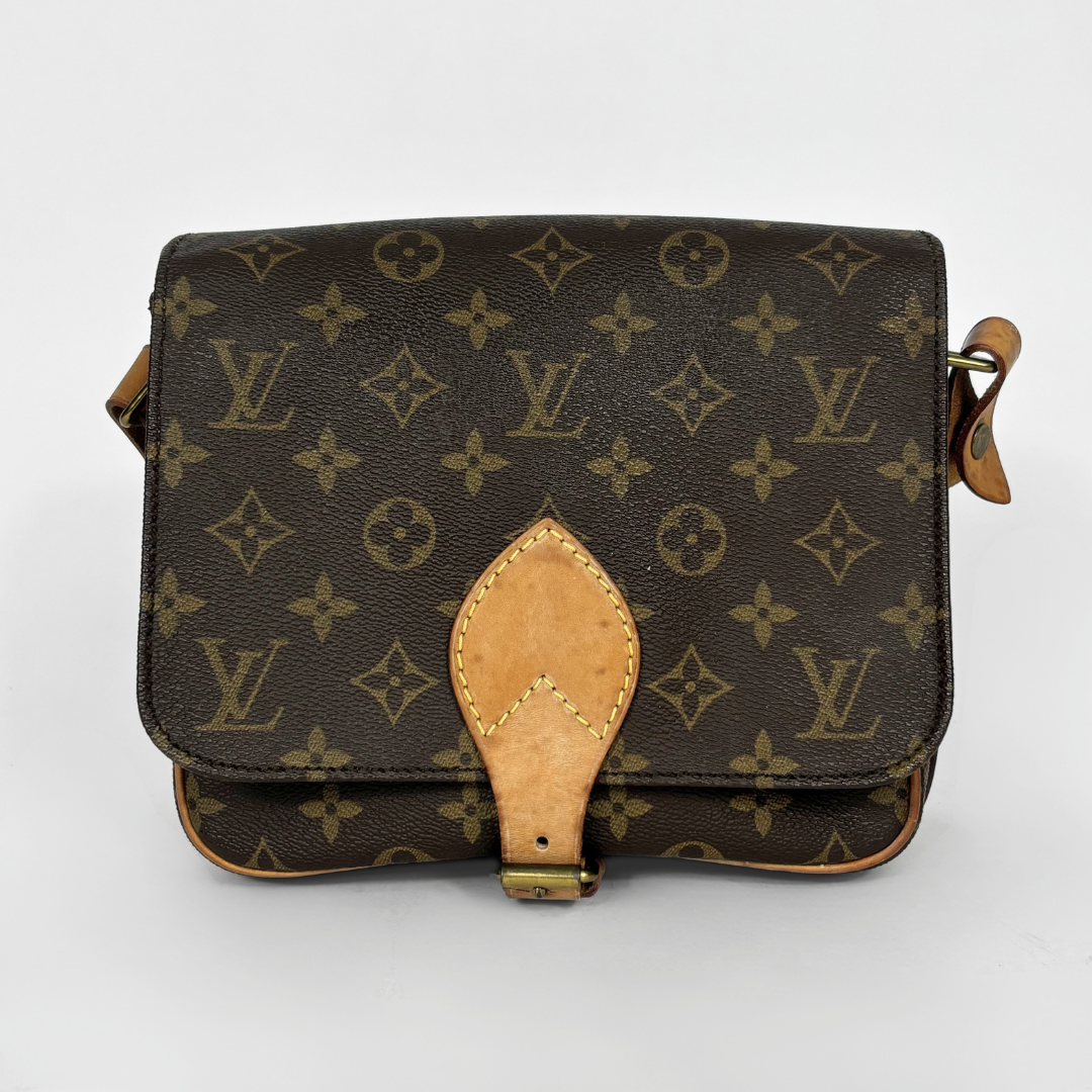 Louis Vuitton monogram handbag on a light gray background