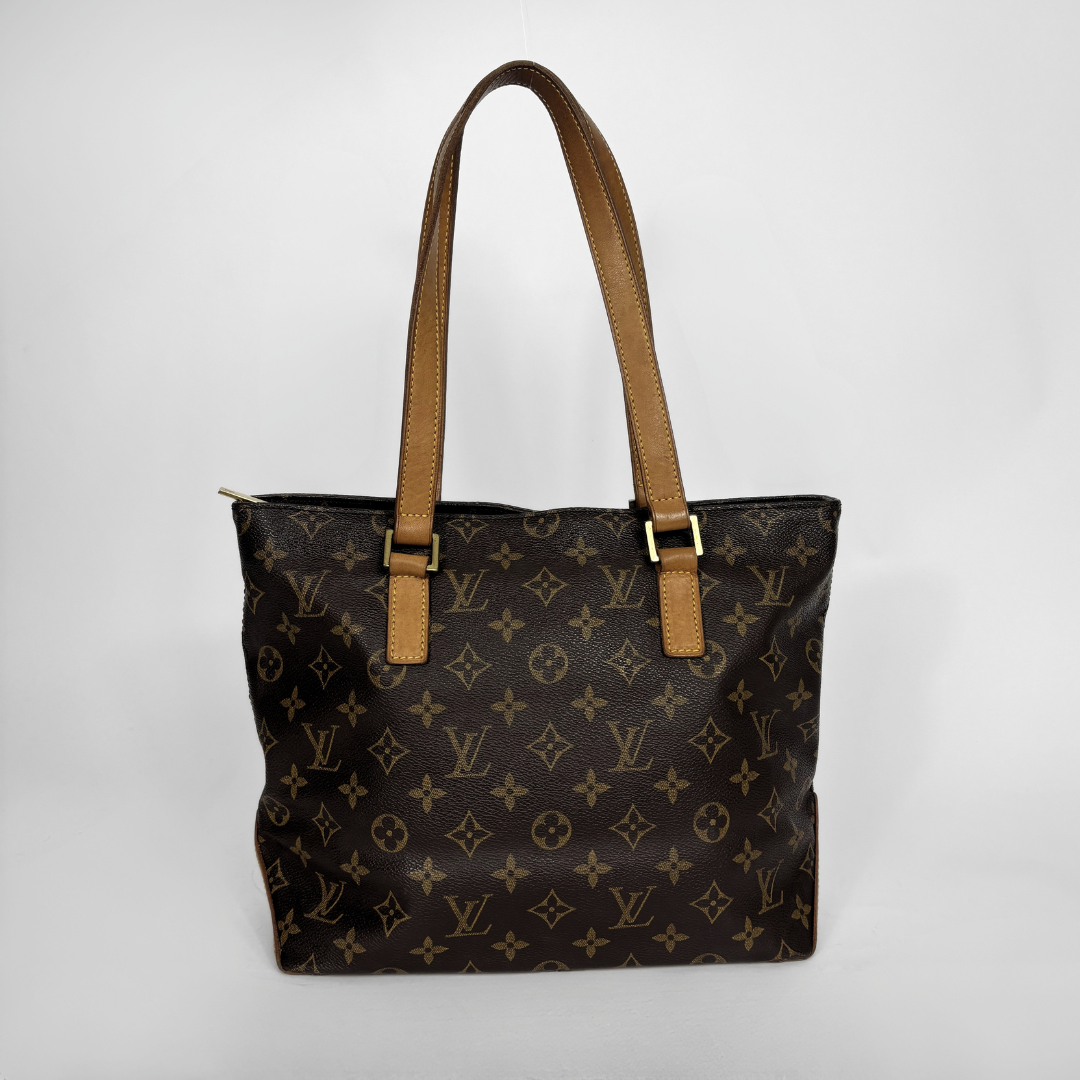 Louis Vuitton monogram canvas tote bag with tan leather shoulder straps and gold-tone hardware, photographed against a light gray studio background.