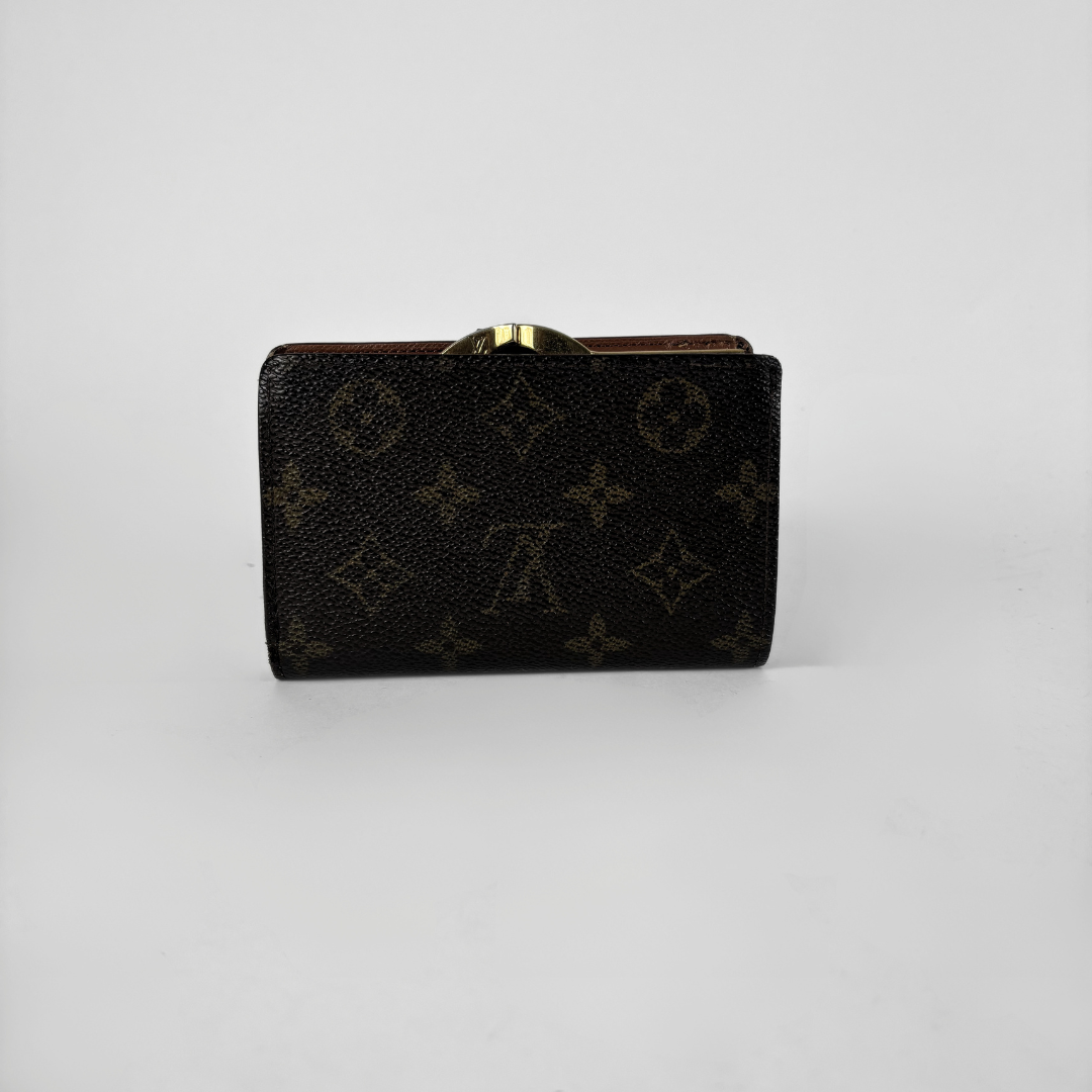 A Louis Vuitton monogram wallet in black coated canvas with a gold-tone metal clasp, shown on a neutral light gray background.