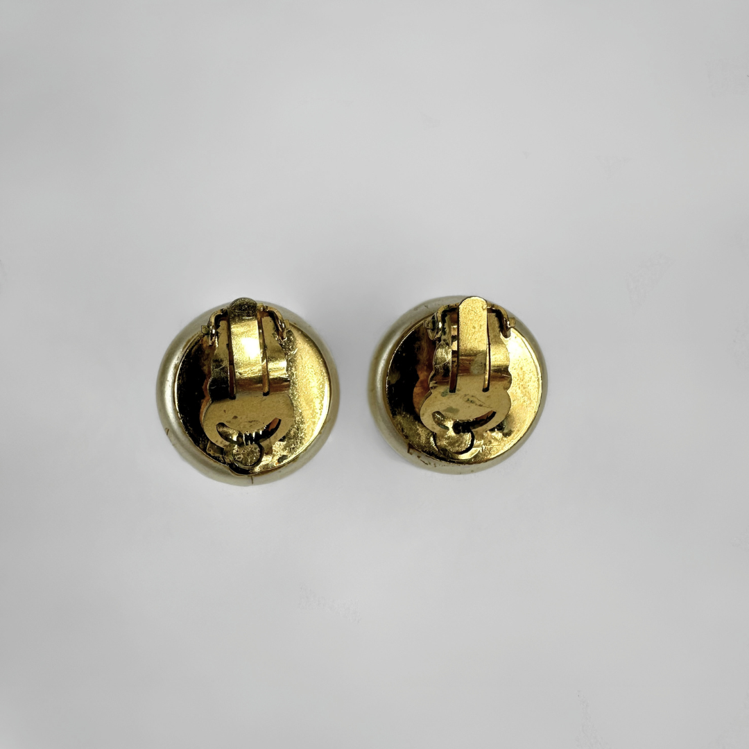 Two gold-tone round stud earrings shown from the back on a plain light gray background.