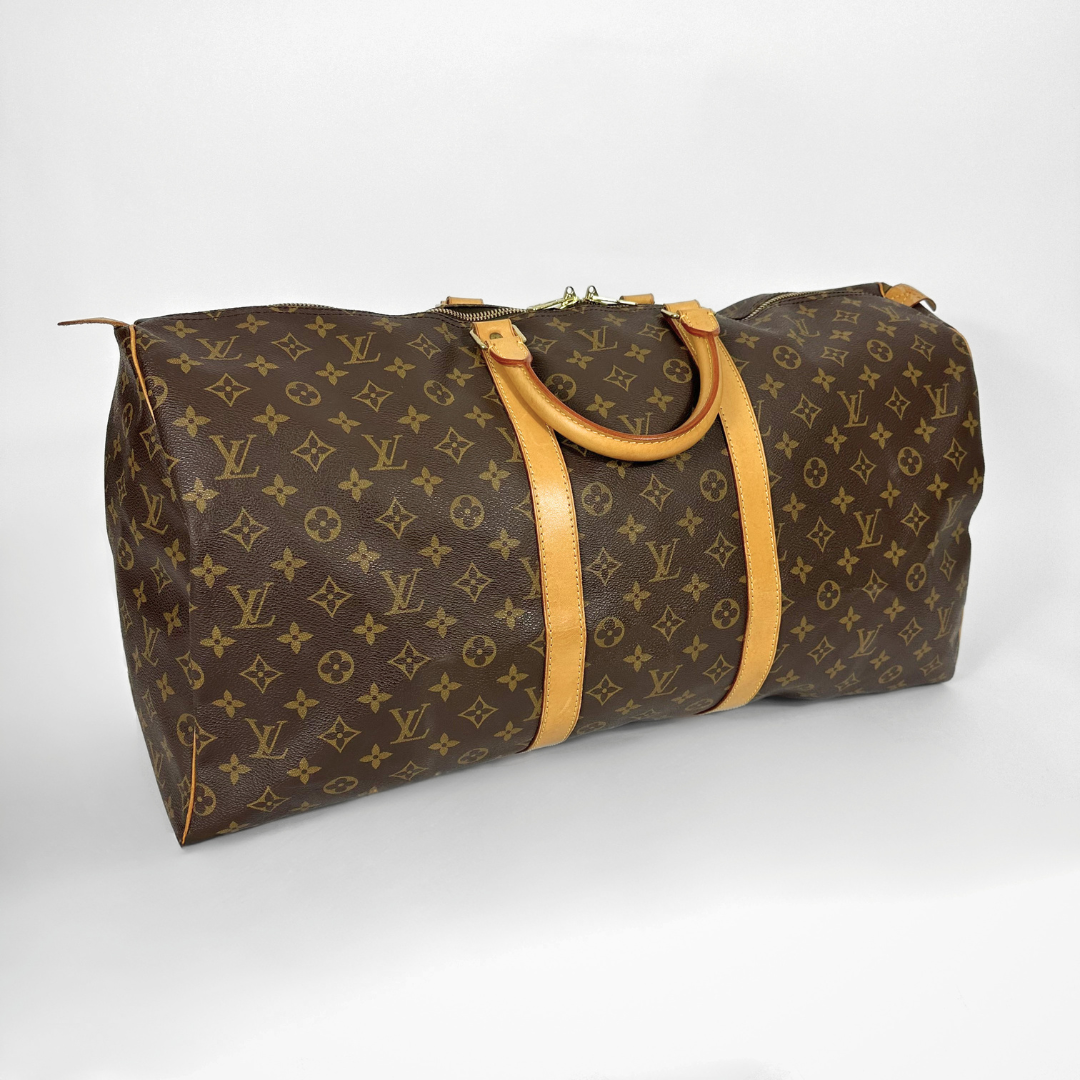 Louis Vuitton monogram duffel bag with tan handles on a white background