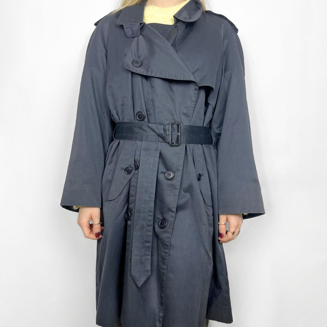 Gray trench coat worn by a person on a white background