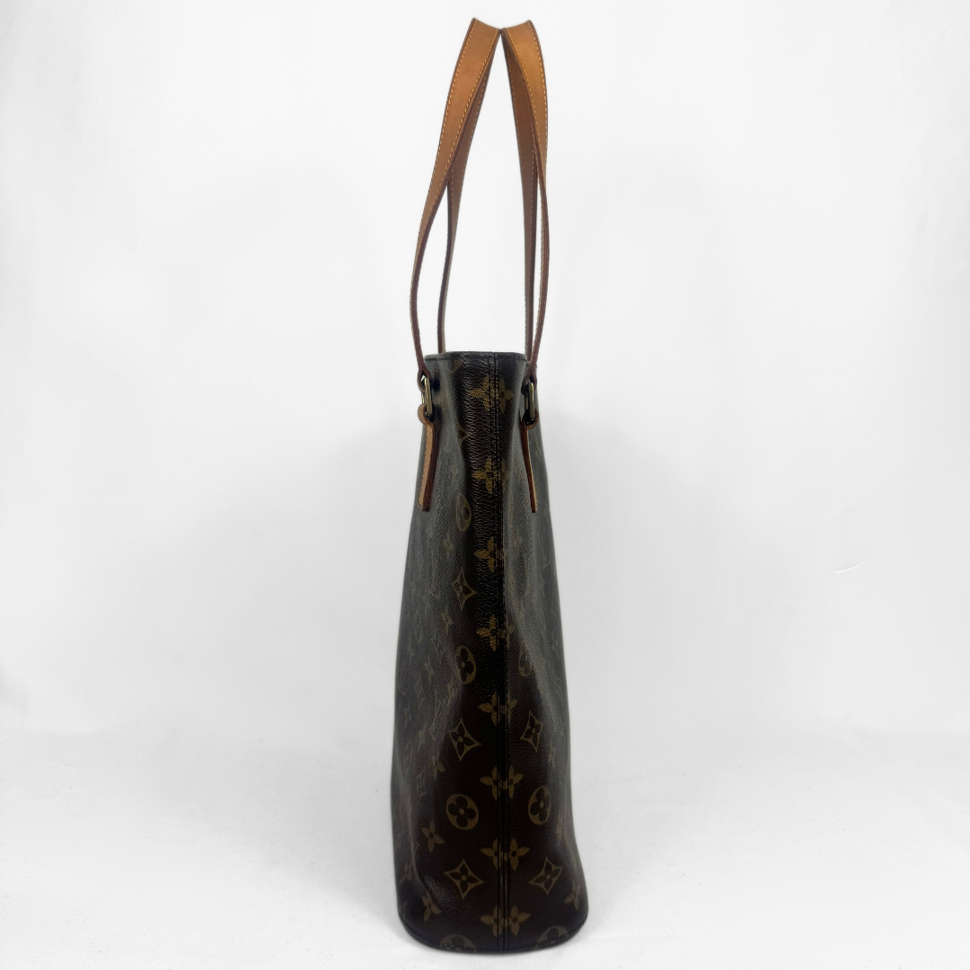 A Louis Vuitton monogram canvas bag in dark brown with tan leather shoulder straps, shown from the side against a plain white background.