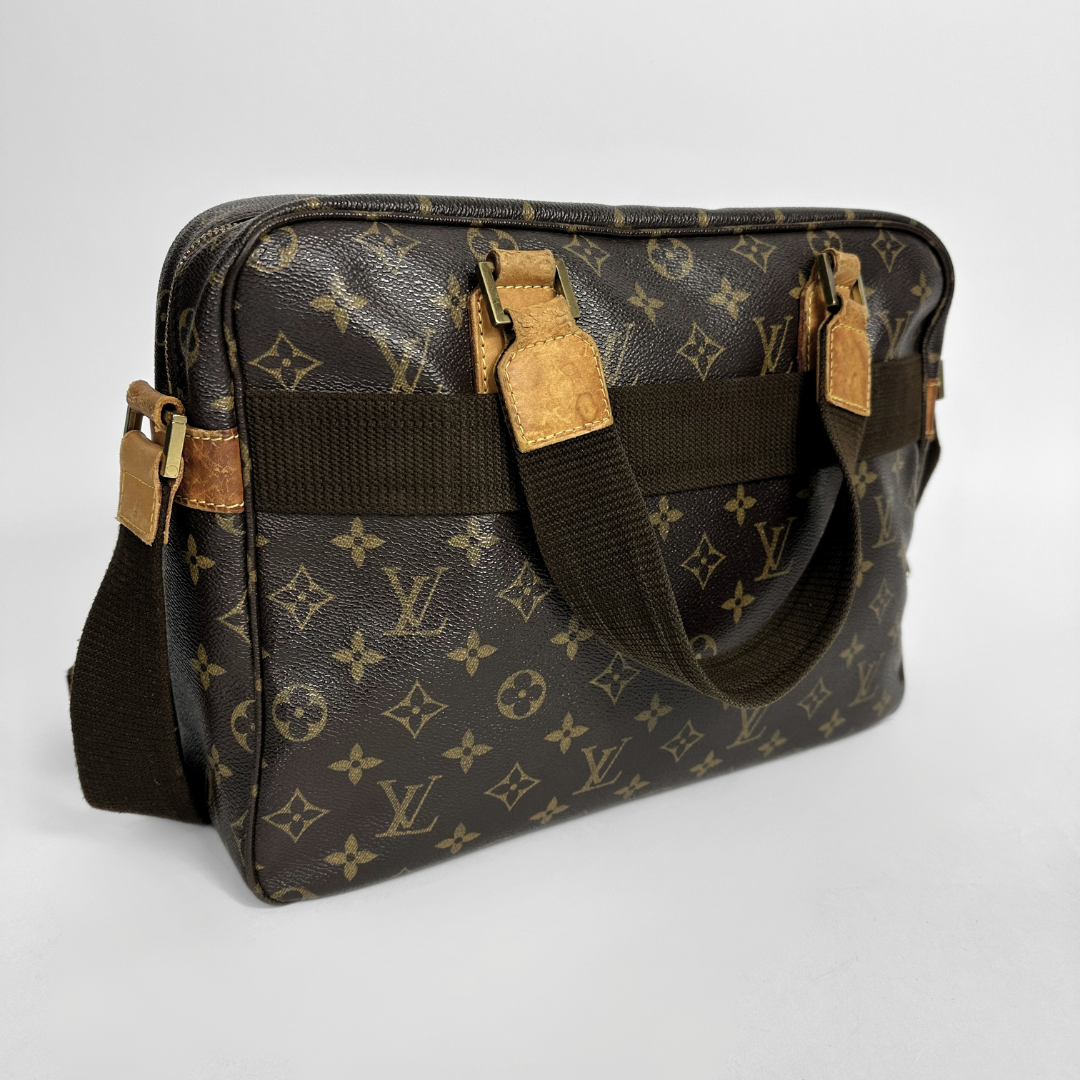 Designer handbag with monogram pattern on a light gray background