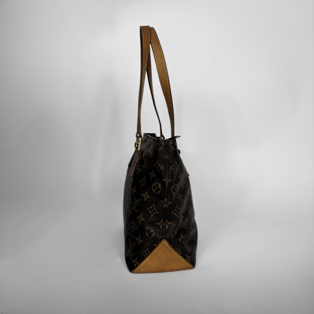 A Louis Vuitton monogram canvas shoulder bag with brown leather trim and a triangular tan leather base, shown against a plain light gray background.