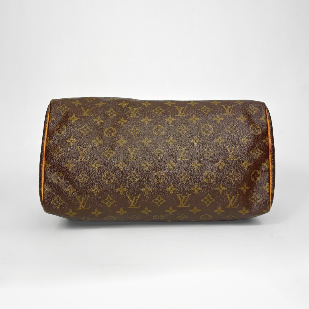 Brown handbag with monogram pattern on a white background