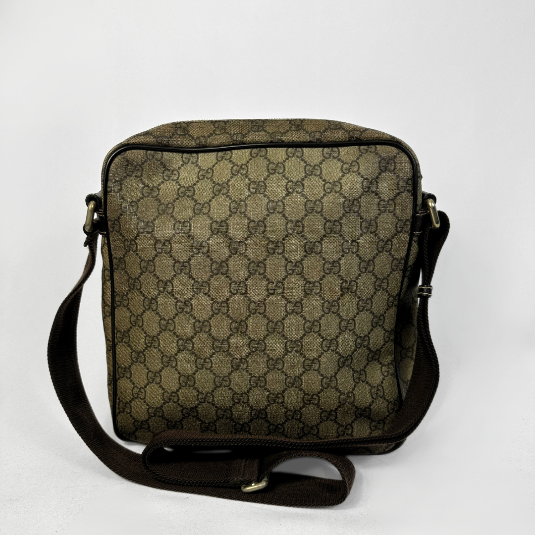 A vintage Gucci shoulder bag in the classic GG Supreme canvas, featuring a brown and beige monogram pattern, dark brown leather trim, and an adjustable shoulder strap, photographed against a plain white background.