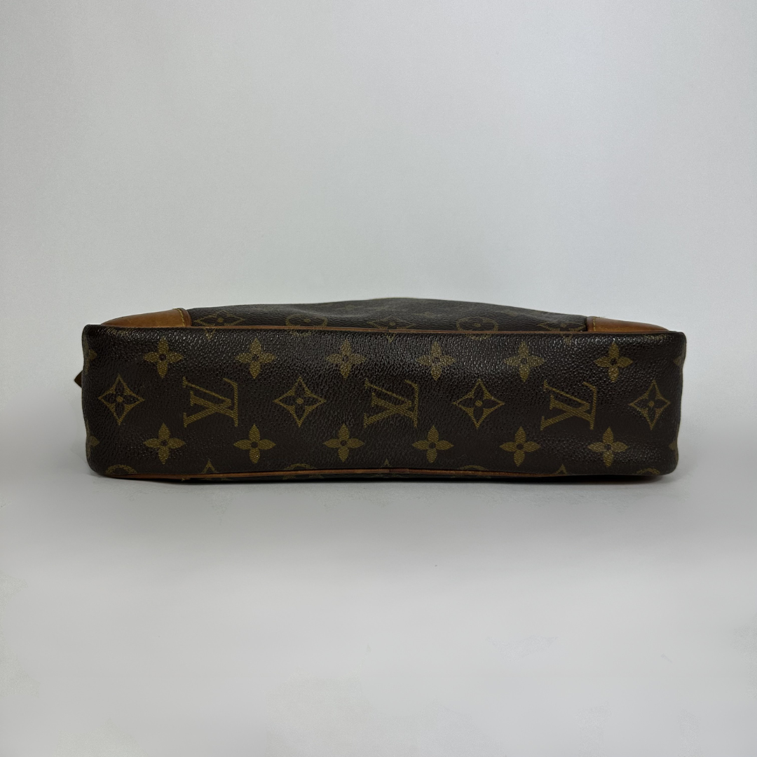 A Louis Vuitton monogram canvas bag shown from the side, featuring the classic dark brown and tan monogram pattern on a light gray background.