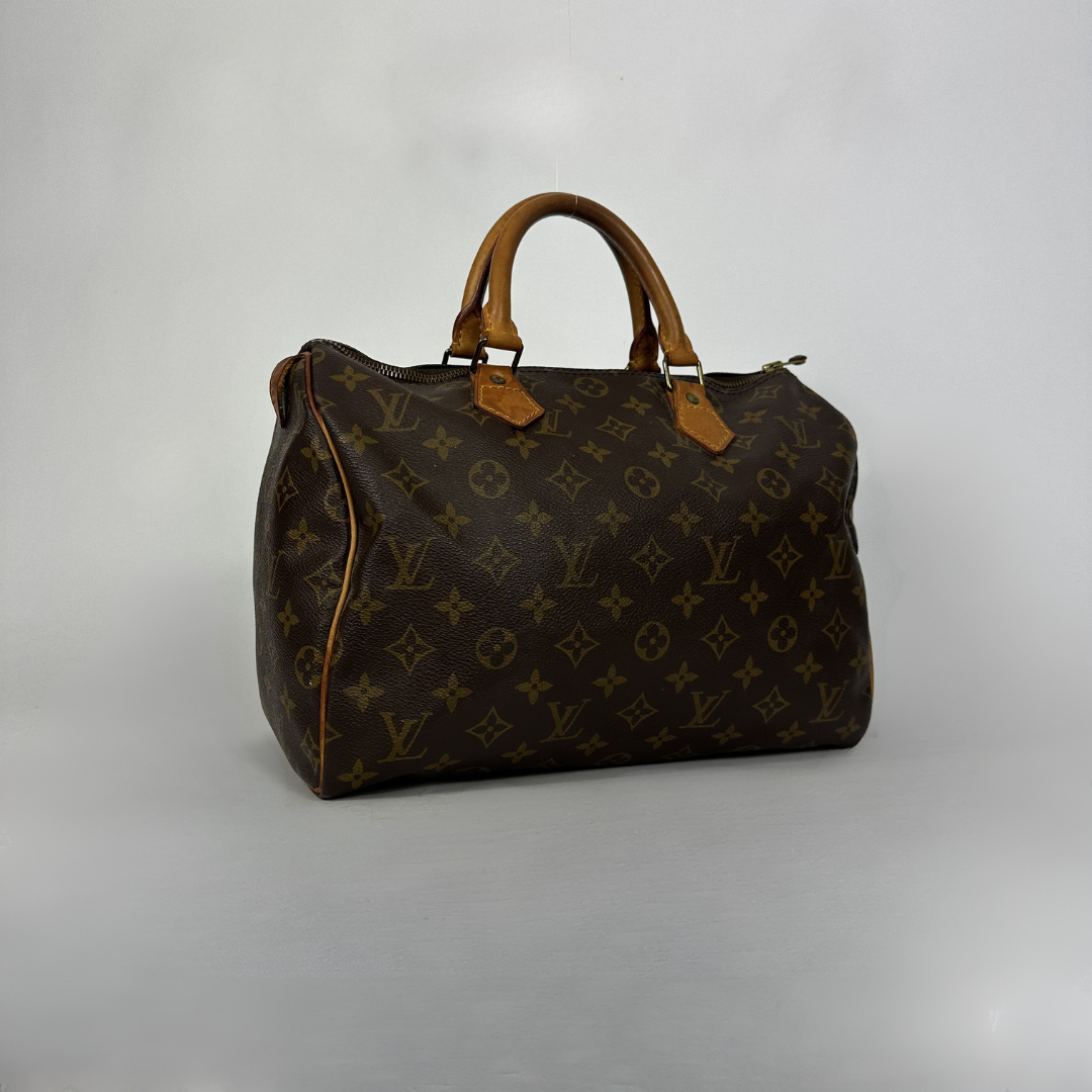 A Louis Vuitton monogram canvas duffel bag with tan leather handles and trim, photographed against a neutral light gray background.