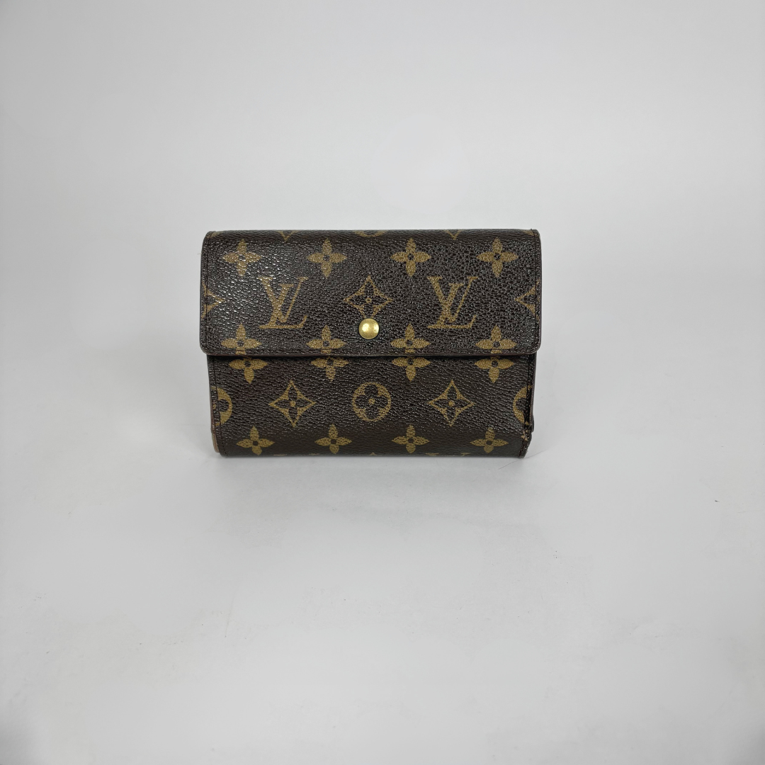 Louis Vuitton wallet with monogram pattern on a light gray background