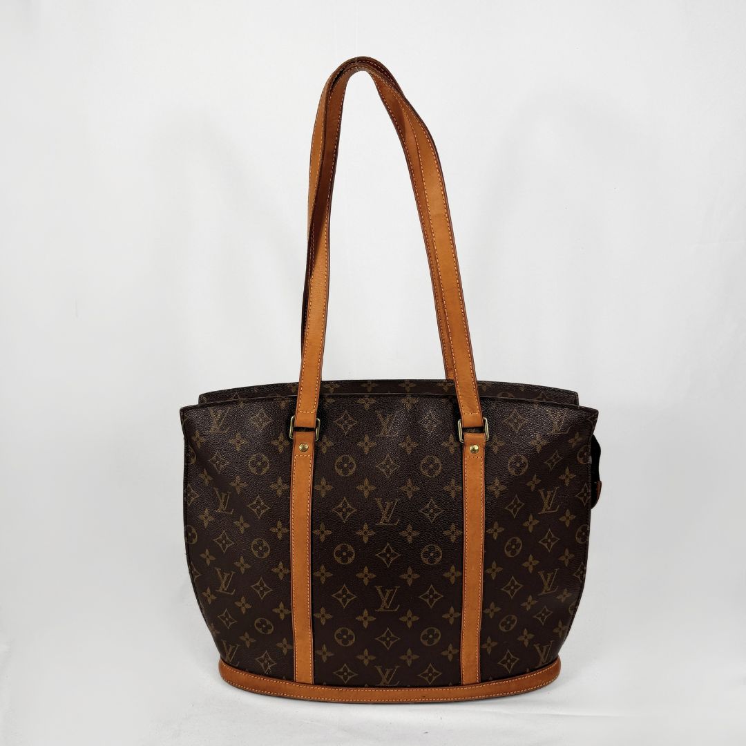 Louis Vuitton monogram canvas tote bag with tan leather shoulder straps and trim, shown against a plain white background.