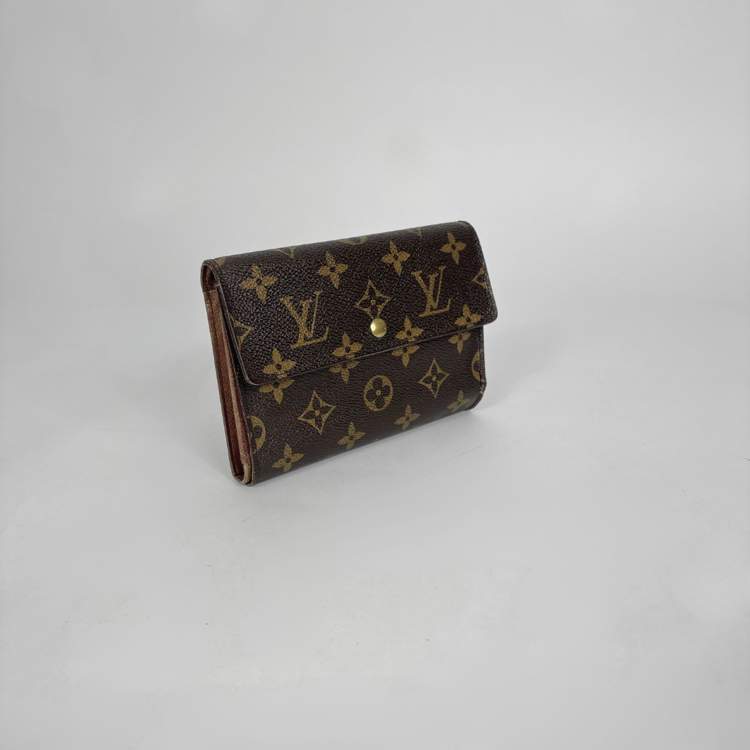 Brown wallet with monogram pattern on a light gray background
