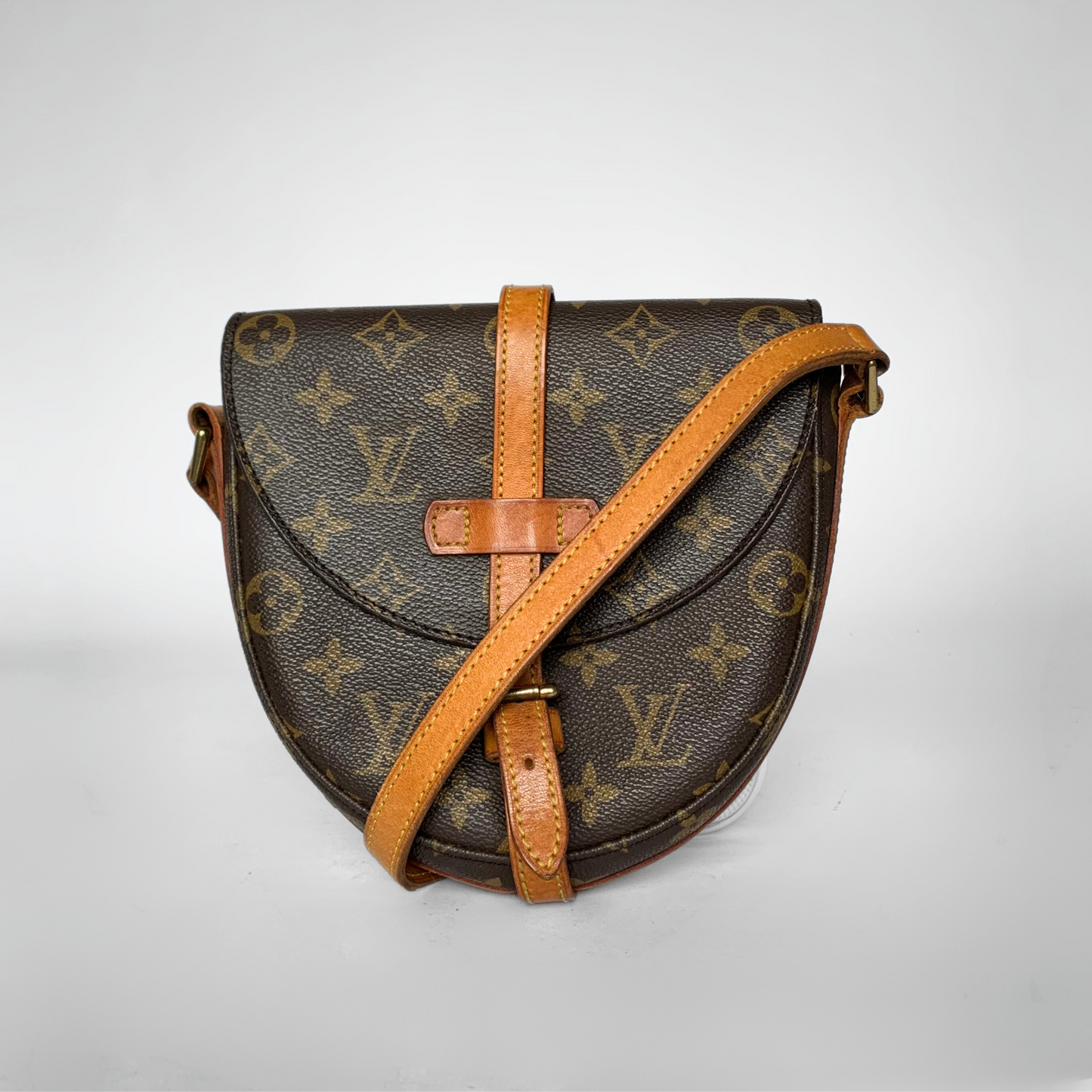 Designer handbag with monogram pattern on a light gray background