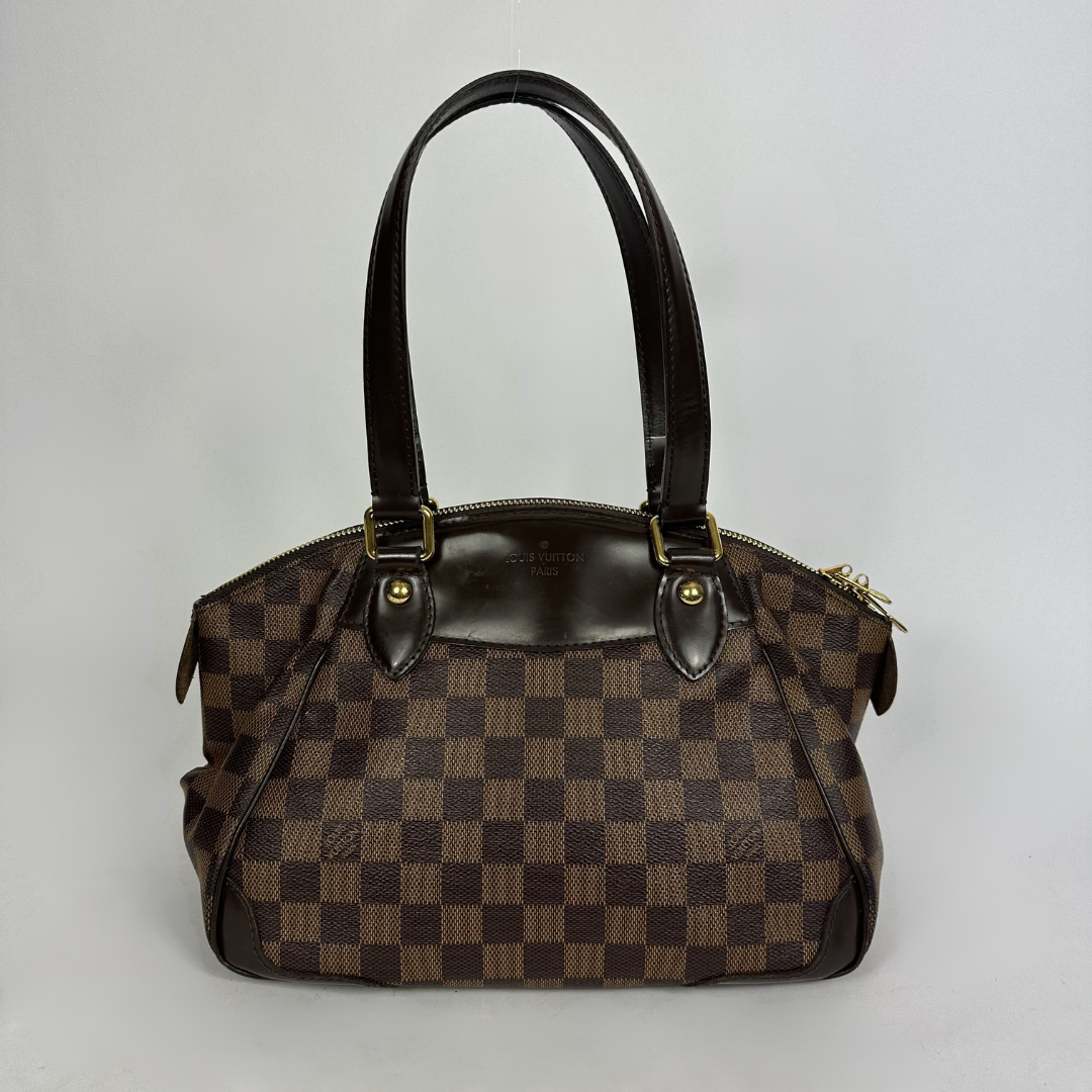 A Louis Vuitton handbag in the Damier Ebene in front of white background