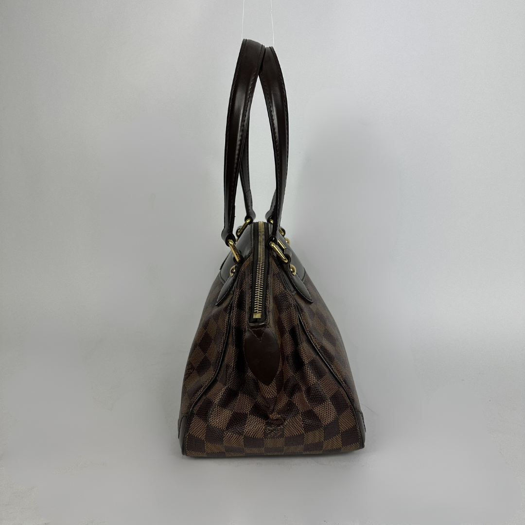 A Louis Vuitton handbag in the Damier Ebene in front of white background