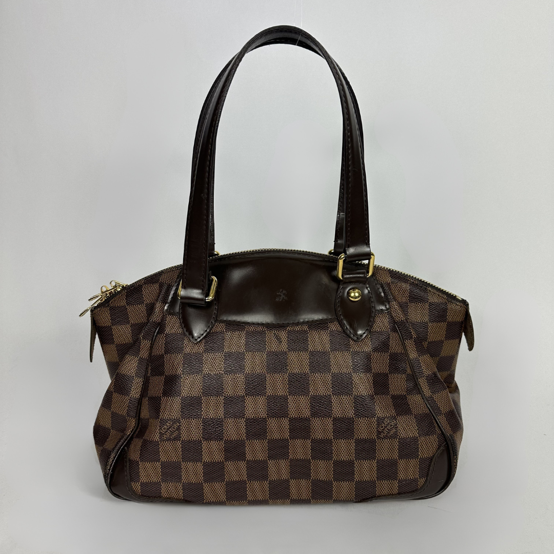 A Louis Vuitton handbag in the Damier Ebene in front of white background
