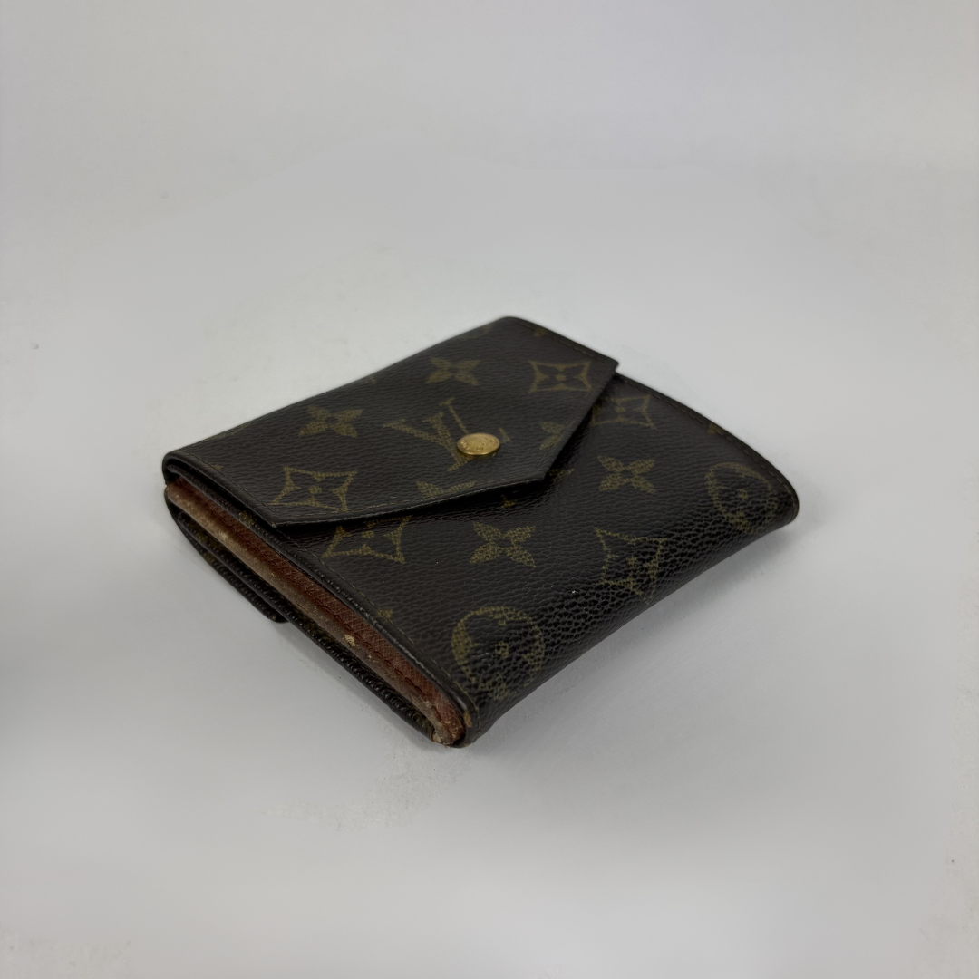 A classic Louis Vuitton monogram bifold wallet in dark brown coated canvas with gold-tone hardware, photographed on a neutral light gray background.