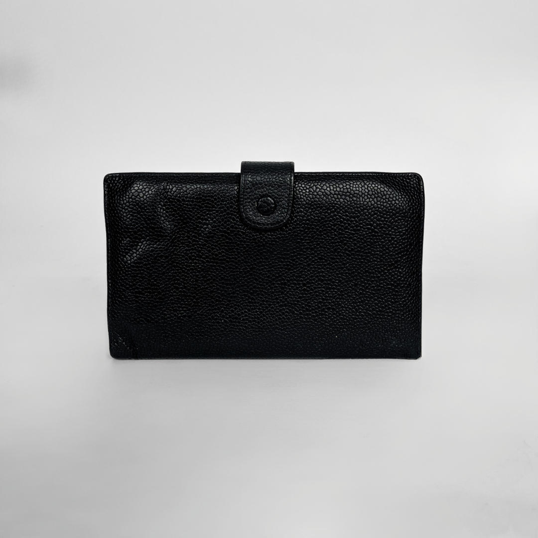 A black textured leather wallet with a snap-button strap closure, photographed against a neutral light gray background.