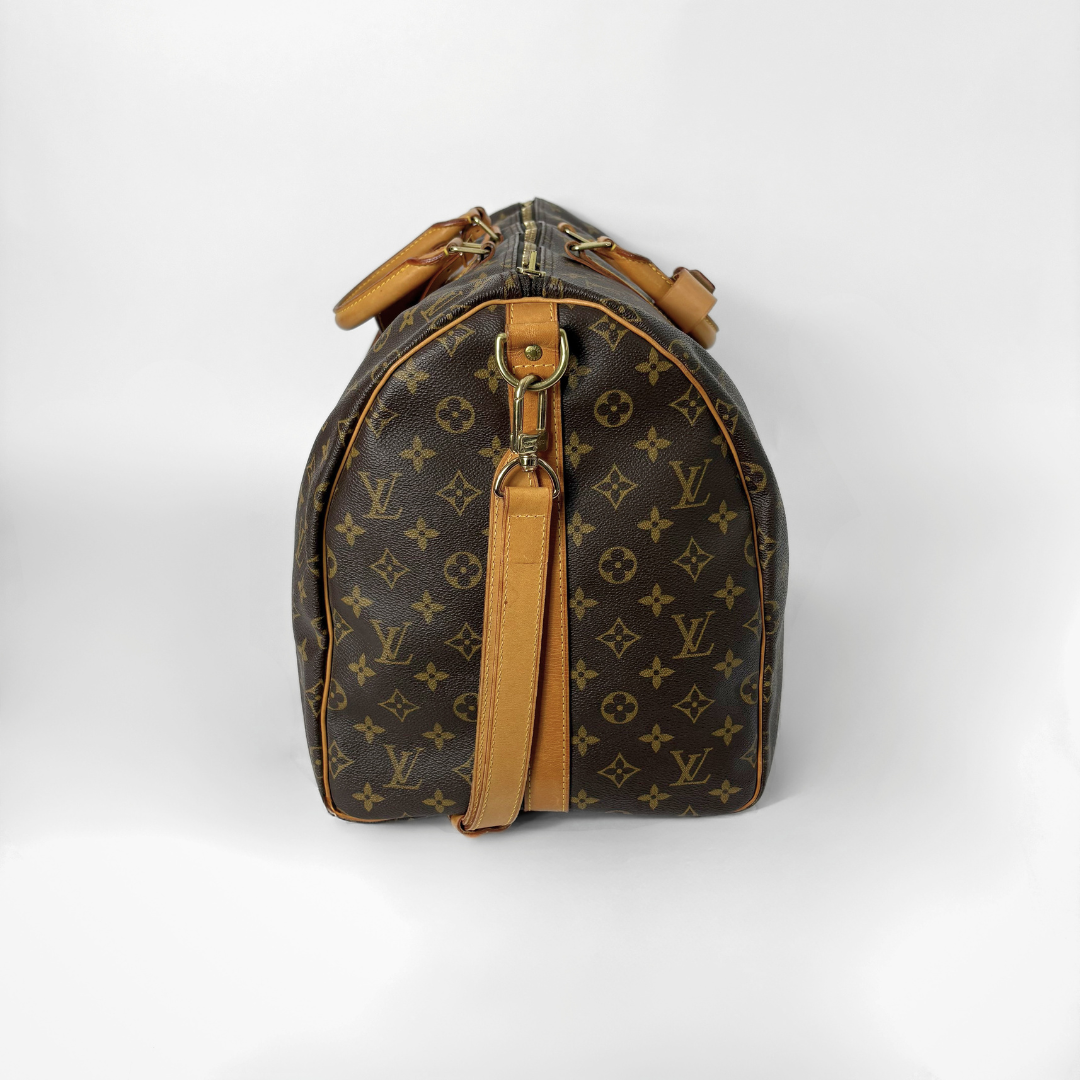 Brown monogram duffel bag with tan leather straps on a white background