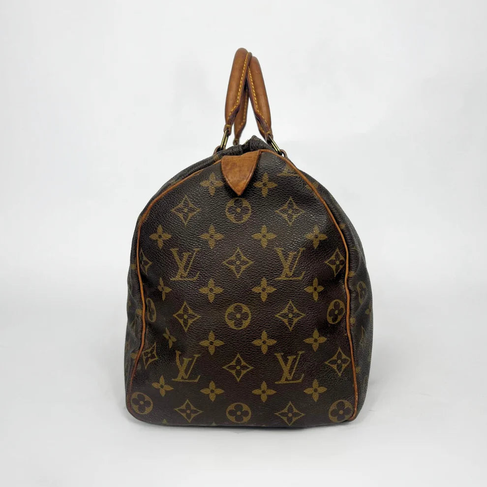 Brown leather handbag with monogram pattern on a white background