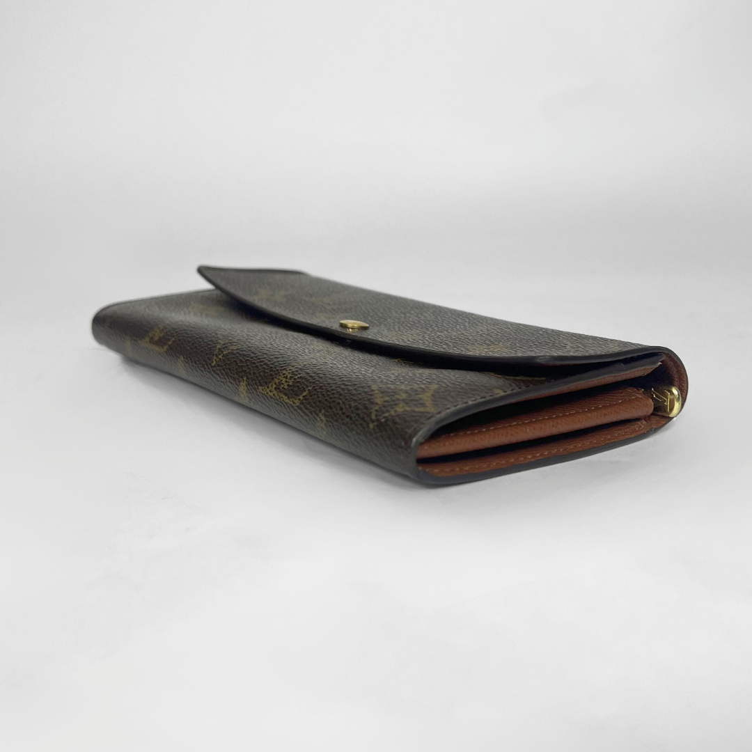 Brown leather wallet with gold accents on a white background