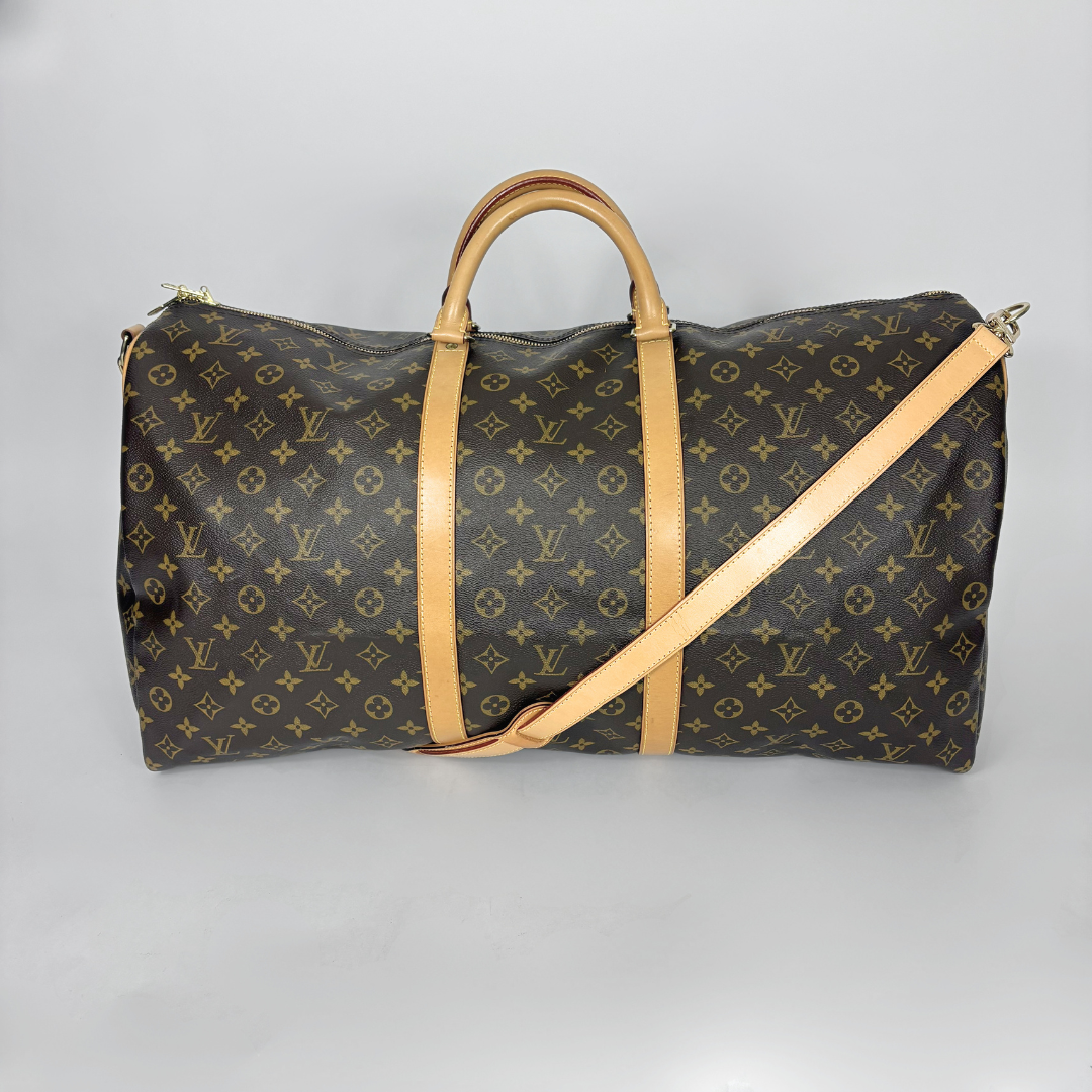 Designer travel bag with monogram pattern on a gray background