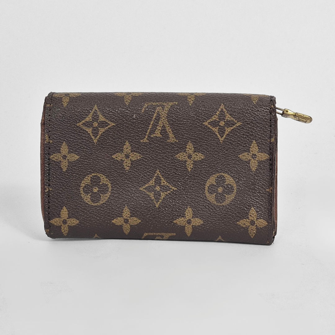 Brown wallet with gold monogram pattern on a light gray background